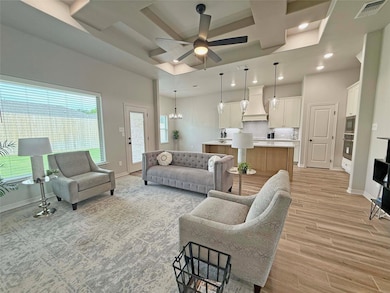 Living area with coffered ceiling, baseboards, lig