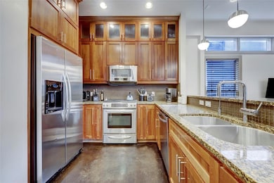 Kitchen with brown cabinets, finished concrete fl