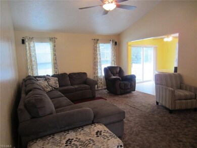 Living room with vaulted ceilings, fan, opens to k
