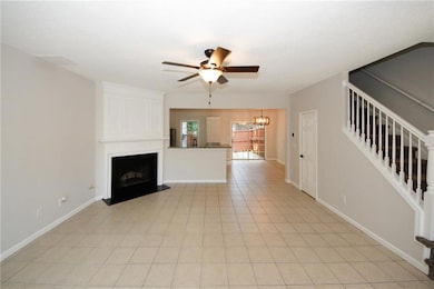 Unfurnished living room featuring stairs, a large fireplace, ceiling fan, a chandelier, and light tile patterned floors