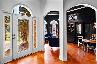 Foyer entrance with arched walkways, wood finished floors, and plenty of natural light