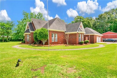 View of front of home with brick siding, a front yard, roof with shingles, and a garage