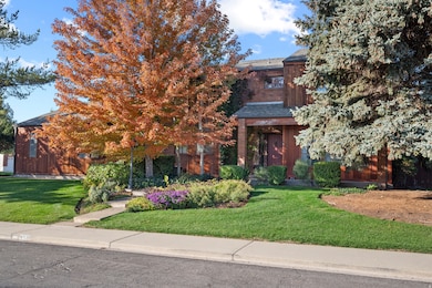View of property hidden behind natural elements featuring a front yard and a shingled roof