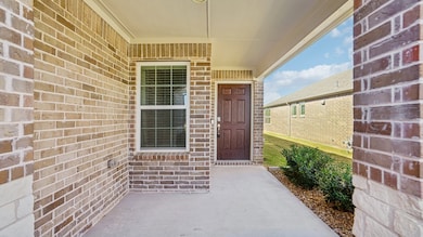 Entrance to property featuring a porch and brick siding