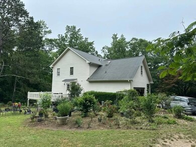 Back of house featuring roof with shingles, a wooden deck, and a yard