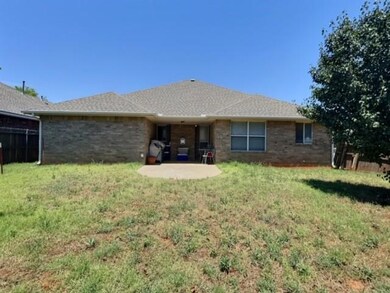 Rear view of house with a lawn and a patio