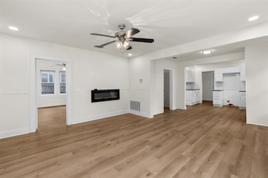 Unfurnished living room with a glass covered fireplace, light wood-type flooring, and recessed lighting