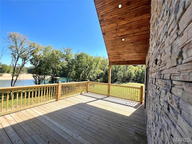 Wooden terrace with a water view and a yard