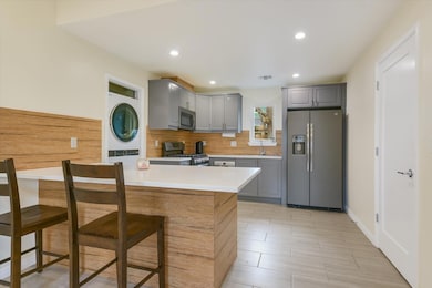 Kitchen with stainless steel appliances, gray cab