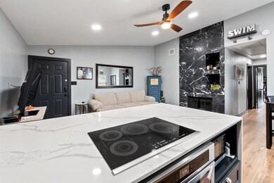 Kitchen with a ceiling fan, light wood-style floo