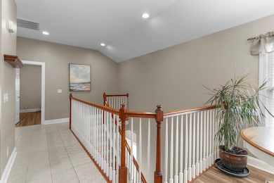 Hall with lofted ceiling and light hardwood / wood
