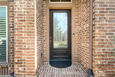 Exterior upgrades with brick elevation. Notice the beautiful stained front door and brick patio.