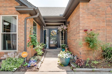 Property entrance with brick siding and a shingled roof