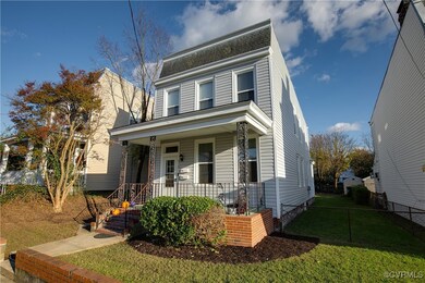 View of front of house with a porch and a front ya