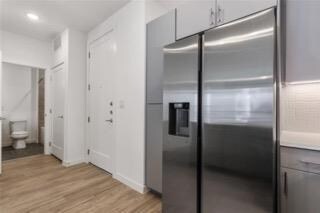 Kitchen featuring stainless steel fridge, light w