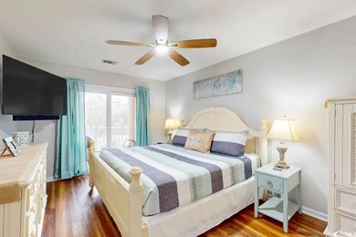 Bedroom featuring ceiling fan and dark wood-type f