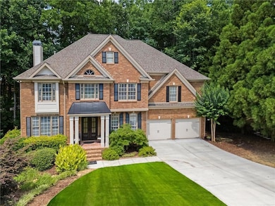 Colonial house with brick siding, concrete driveway, french doors, and a chimney