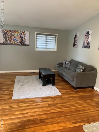 Living area with wood finished floors and baseboards
