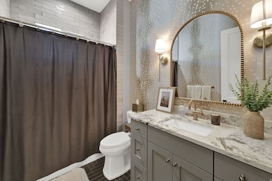 Full bathroom with vanity and dark tile patterned flooring