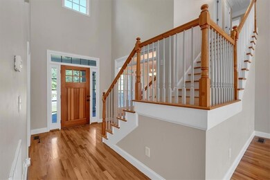 Entrance foyer featuring a high ceiling, wood finished floors, and stairs