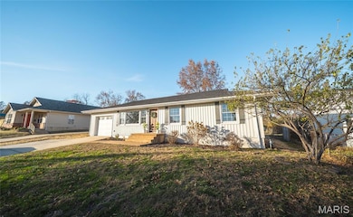 Single story home with board and batten siding, driveway, an attached garage, and a front lawn