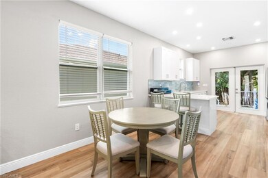 Dining room with french doors, light wood-style floors, and recessed lighting