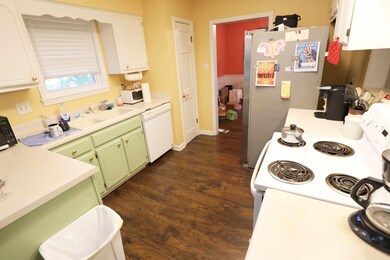 Kitchen featuring white appliances, white cabinets