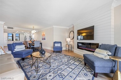 Living room with crown molding, a chandelier, and