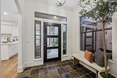 Welcoming entry with glass door framed by tall windows. Note how light and bright from the moment you enter the home.