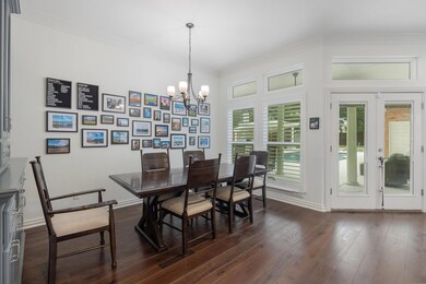 Dining area featuring a chandelier, ornamental molding, dark hardwood / wood-style floors, and french doors