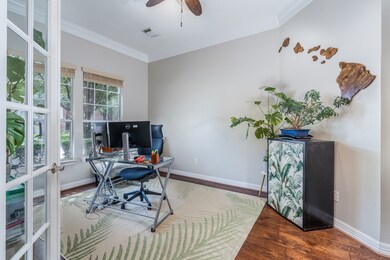 Extra large study with wood floors and French doors at the front of the home.