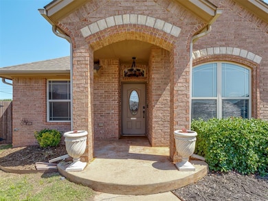 Doorway to property featuring brick siding and roof with shingles