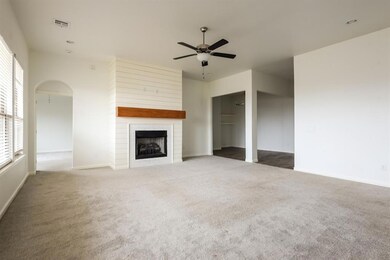 Unfurnished living room featuring arched walkways,