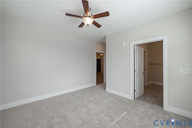 Unfurnished bedroom featuring light carpet and ceiling fan
