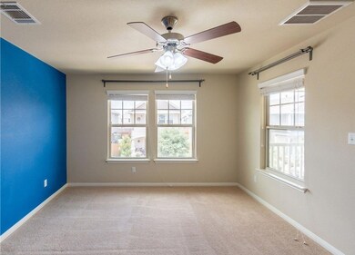 Empty room featuring carpet, visible vents, and a