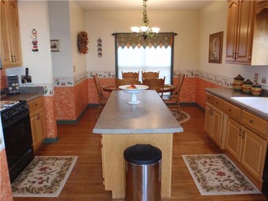 Kitchen has abundant cabinet space, a kitchen island, gas top stove, and access door to the deck