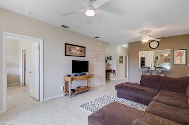 Living area featuring a ceiling fan and light tile patterned floors
