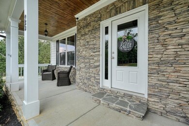 Entrance to property with stone siding and covered porch