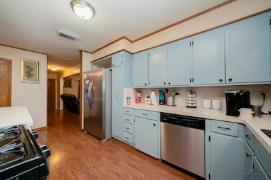 Kitchen with blue cabinetry, light wood-type floor