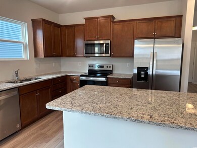Kitchen with light stone countertops, stainless st