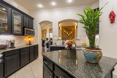 Kitchen with tasteful backsplash, sink, dark stone