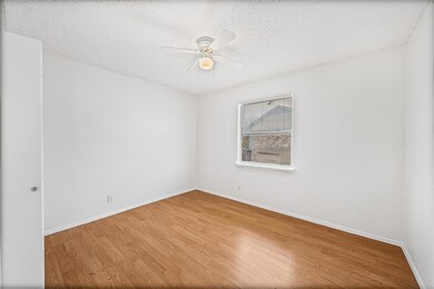 Spare room with baseboards, a textured ceiling, a