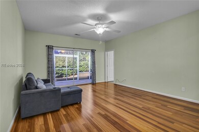 Living room featuring ceiling fan, hardwood / wood