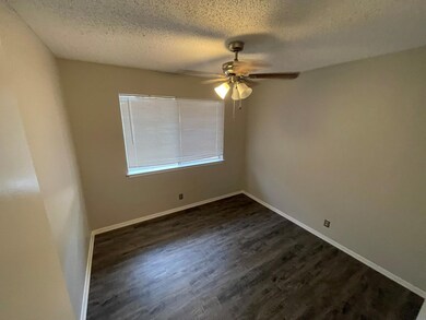 Empty room with ceiling fan, dark wood-style floo