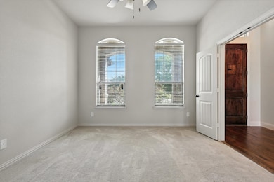 Unfurnished room featuring a ceiling fan, plenty of natural light, and carpet flooring