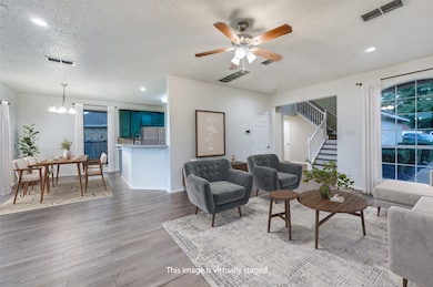 Living area with recessed lighting, a textured ceiling, ceiling fan, a chandelier, and light wood-style floors