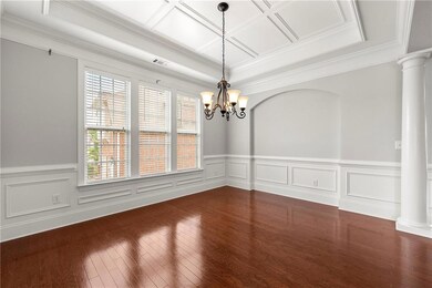 Unfurnished room with decorative columns, crown molding, wainscoting, a chandelier, and coffered ceiling