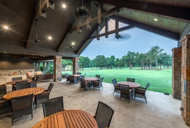 View of patio / terrace with outdoor dining area, view of golf course, an outdoor living space, a ceiling fan, and view of wooded area