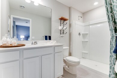 Private bathroom off primary with double vanity and walk-in shower.