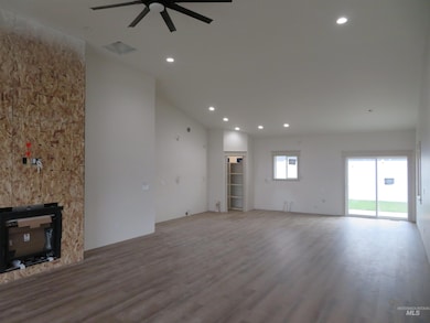Unfurnished living room with recessed lighting, wood finished floors, a glass covered fireplace, and a ceiling fan